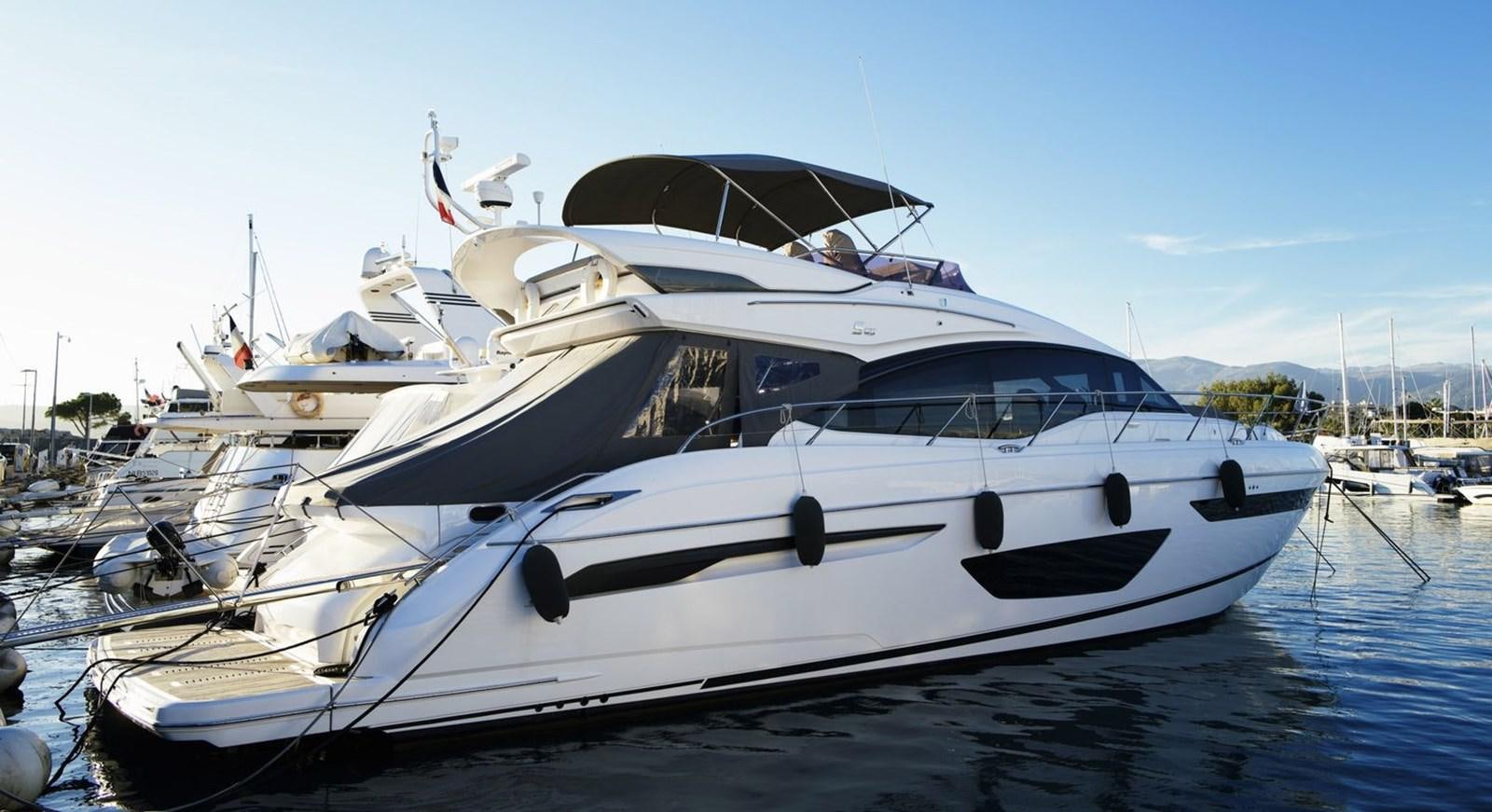 a white yacht in a harbor aboard PRINCESS S65 Yacht for Sale
