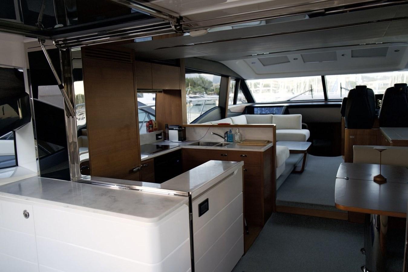 a room with a large window and a table with chairs aboard PRINCESS S65 Yacht for Sale