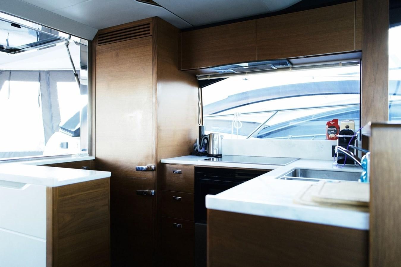 a kitchen with wooden cabinets aboard PRINCESS S65 Yacht for Sale