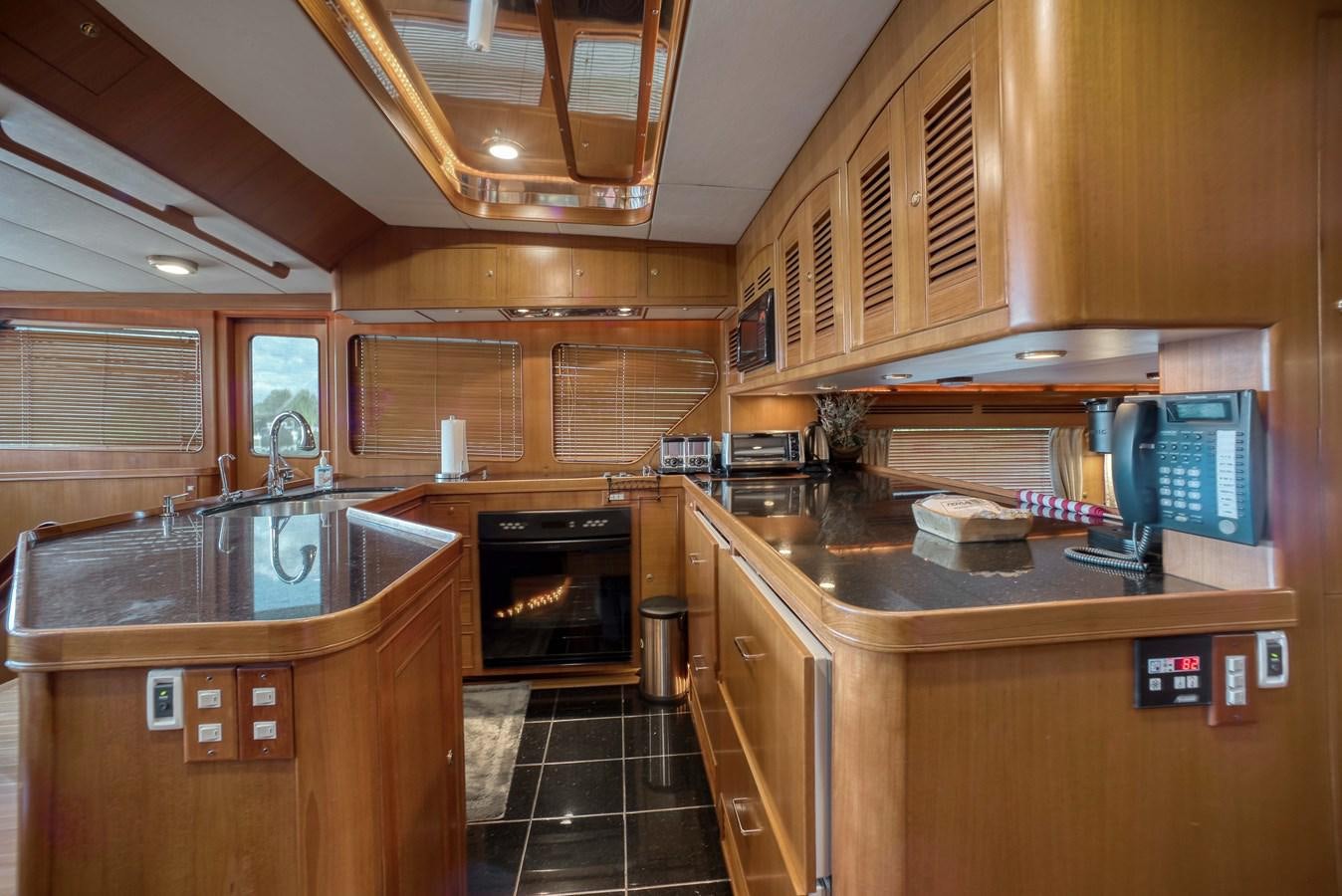 a kitchen with wooden cabinets aboard BLUE ROSY V Yacht for Sale