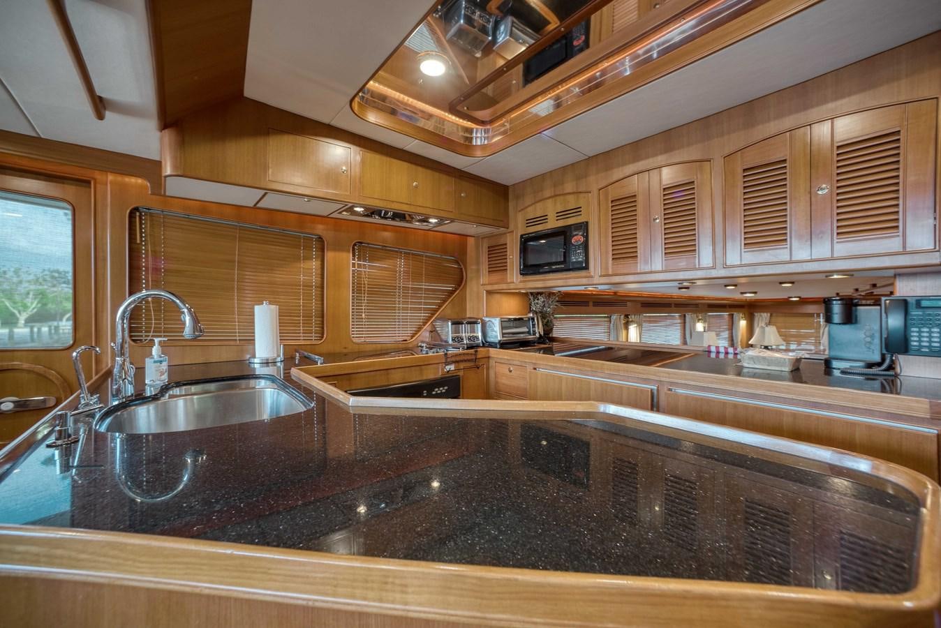 a kitchen with wooden cabinets aboard BLUE ROSY V Yacht for Sale
