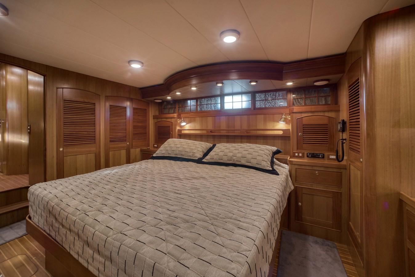 a bedroom with a bed and a dresser aboard BLUE ROSY V Yacht for Sale