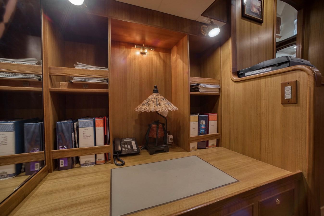 a desk with a lamp and bookshelves aboard BLUE ROSY V Yacht for Sale