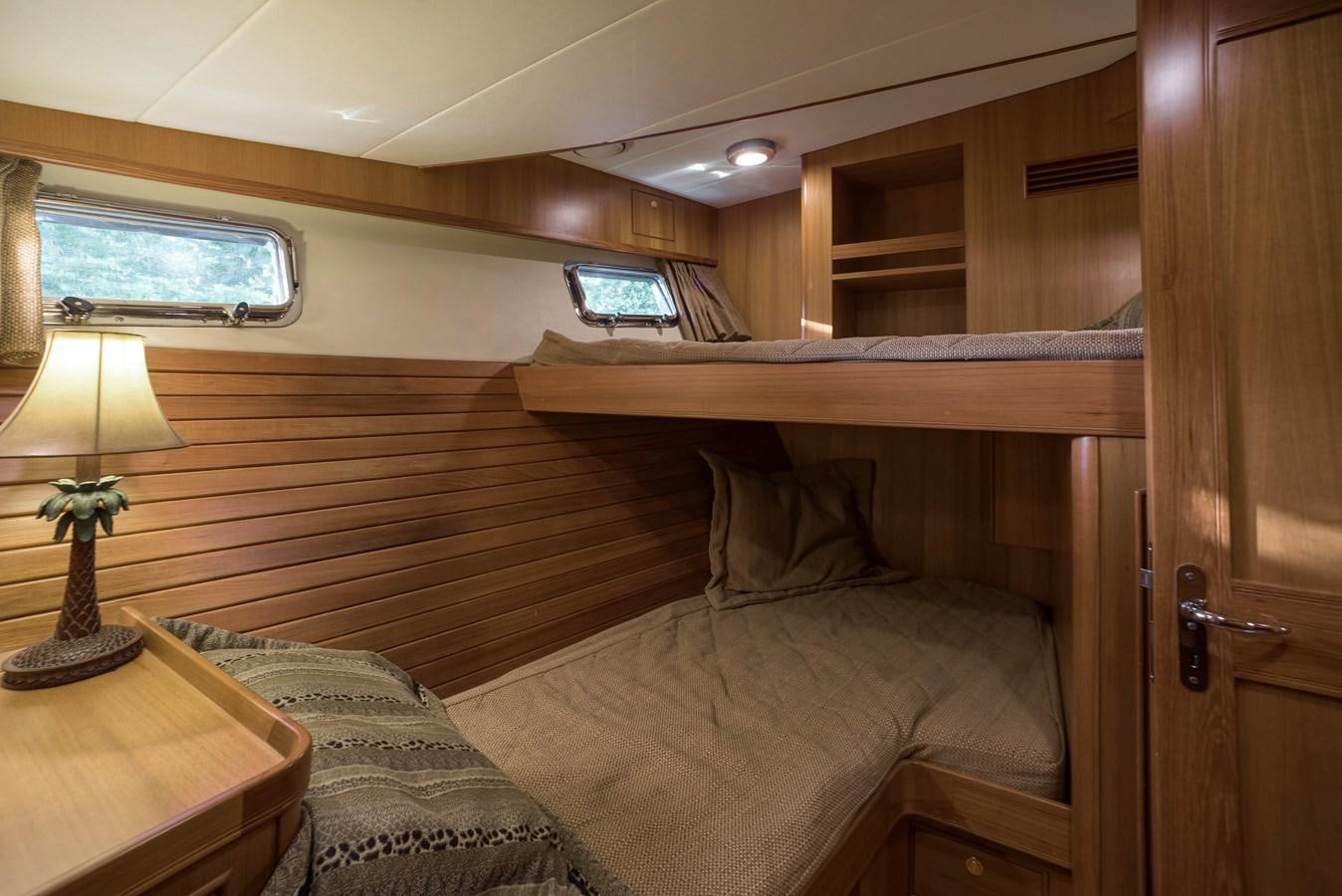 a bedroom with a bed and a desk aboard BLUE ROSY V Yacht for Sale