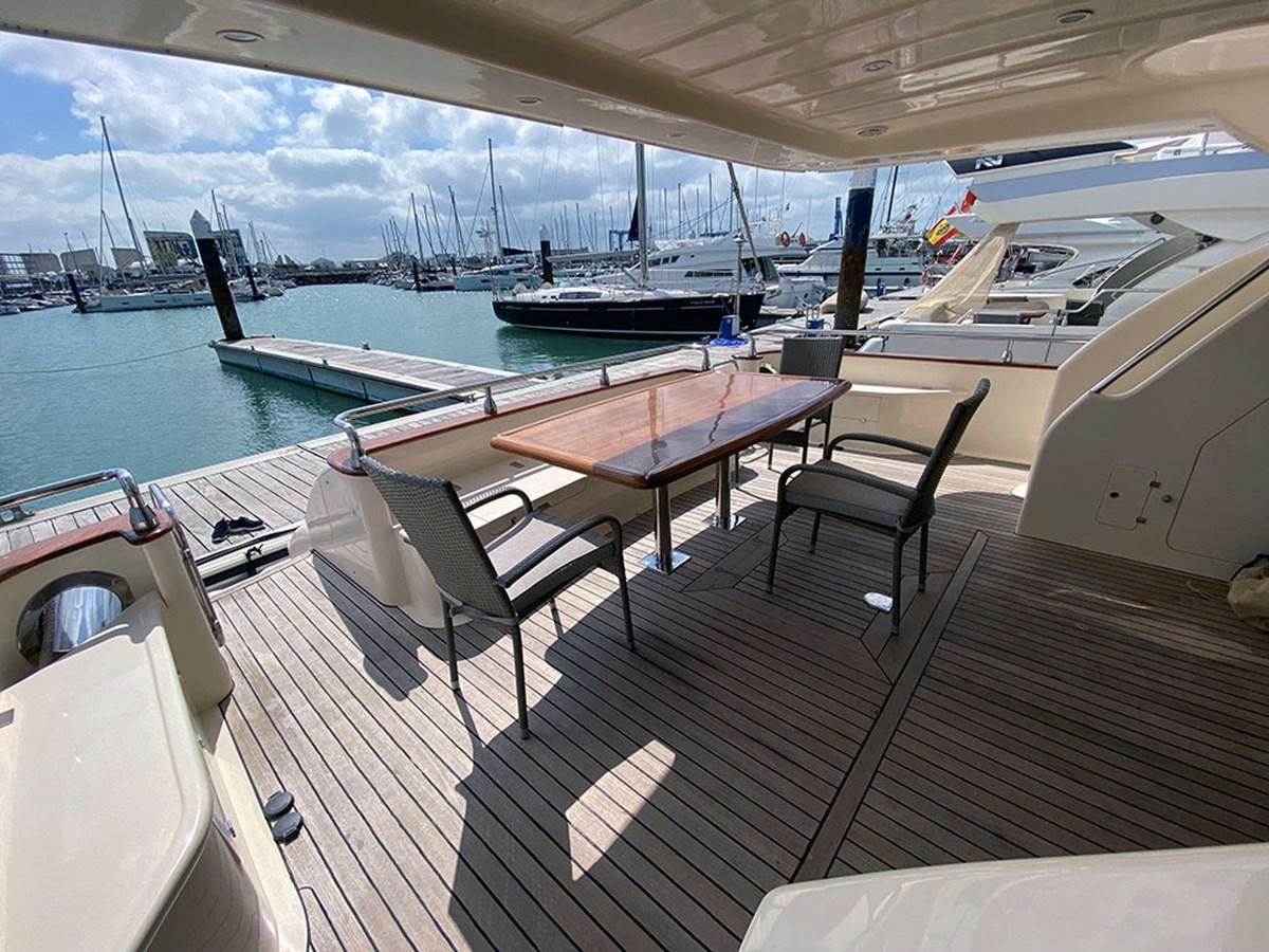 a deck with a table and chairs on it aboard SPEED 5 Yacht for Sale