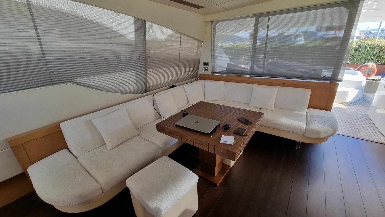 a living room with a table and couches aboard GUSS 97 Yacht for Sale