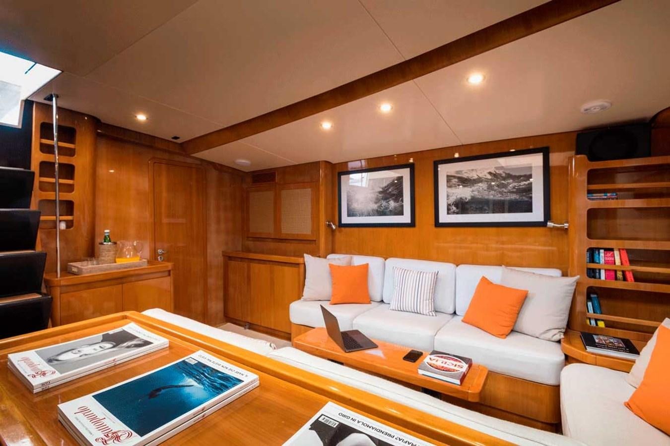a living room with a couch and a book shelf aboard LOGICA Yacht for Sale