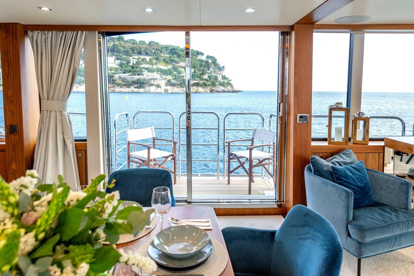 a room with a table chairs and plants aboard TAKE OFF Yacht for Sale