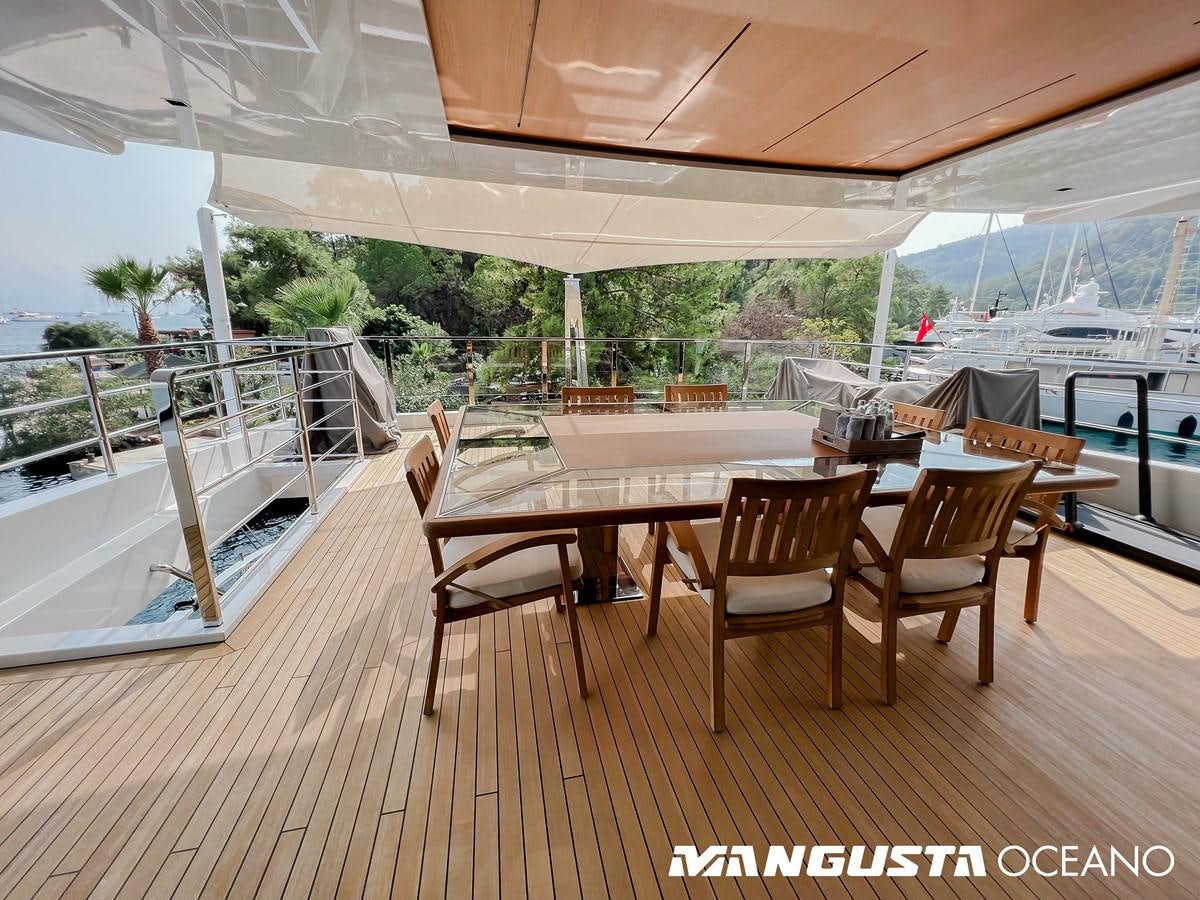 a wood table and chairs on a deck aboard SANCTUARY Yacht for Sale