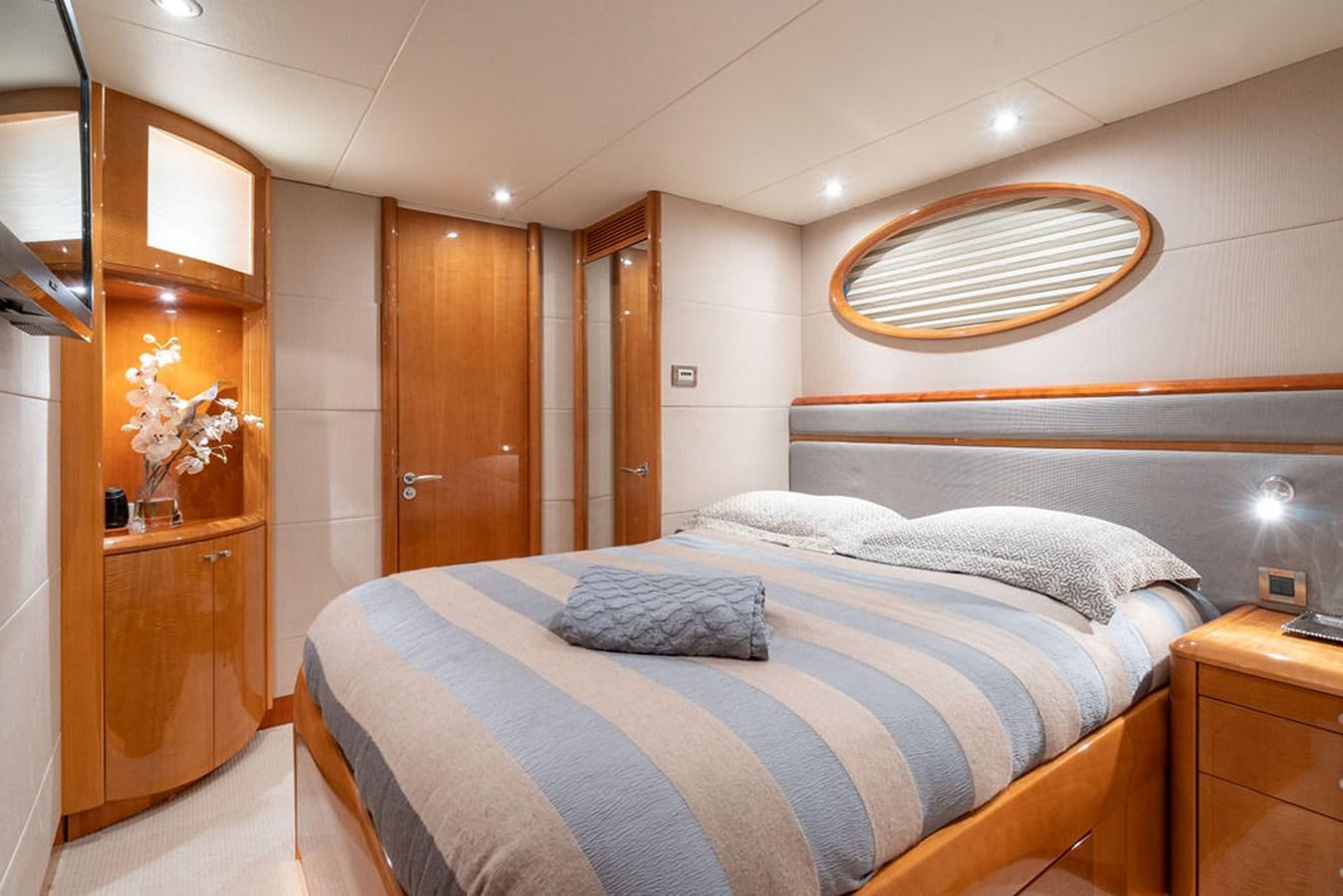 a bedroom with a bed and a dresser aboard CHIP Yacht for Sale