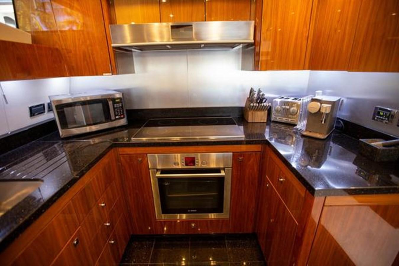 a kitchen with wooden cabinets aboard THE CABANA Yacht for Sale