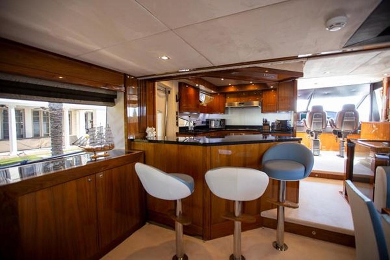a kitchen with stools and tables aboard THE CABANA Yacht for Sale