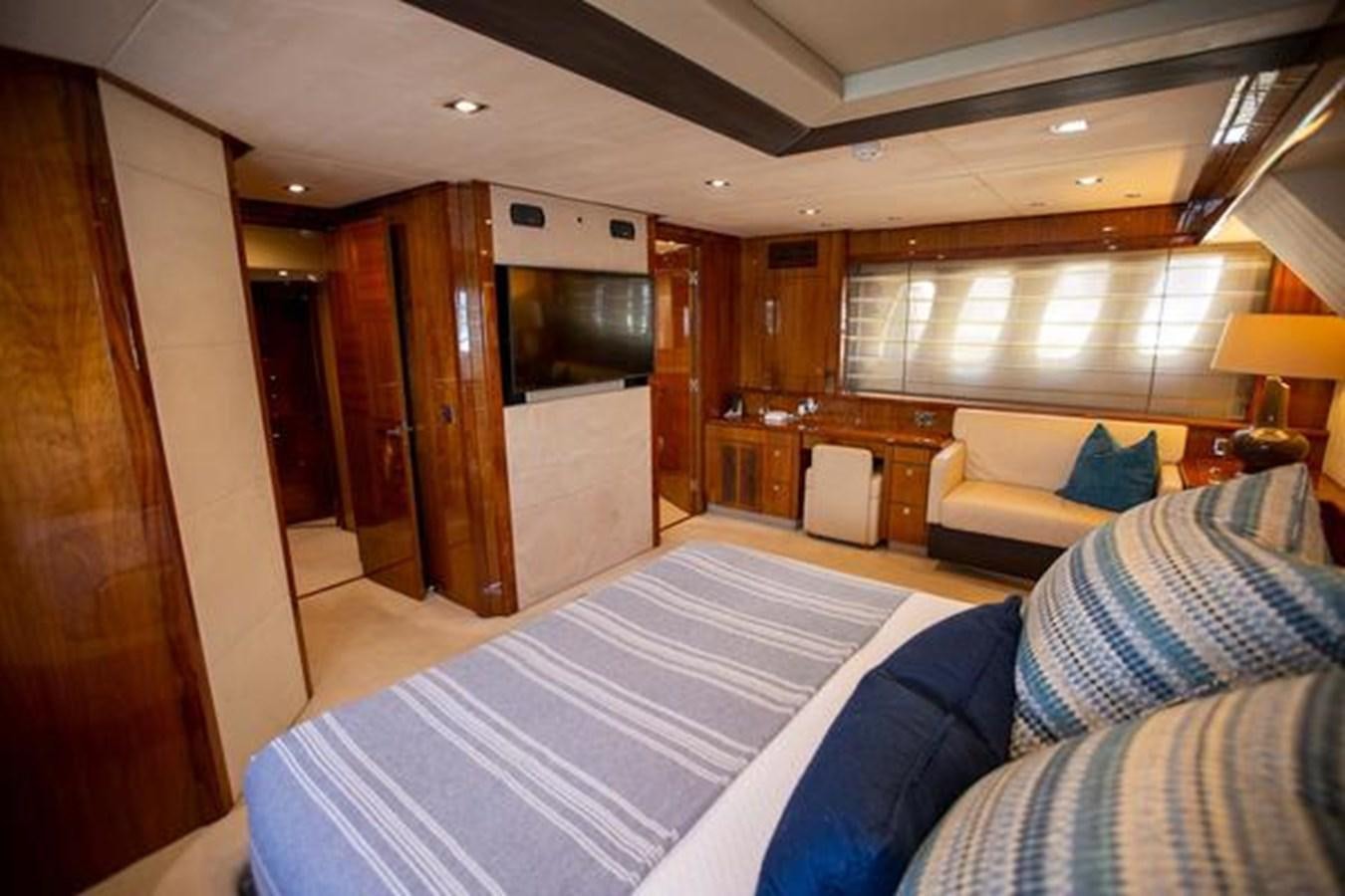 a bedroom with a bed and a desk aboard THE CABANA Yacht for Sale