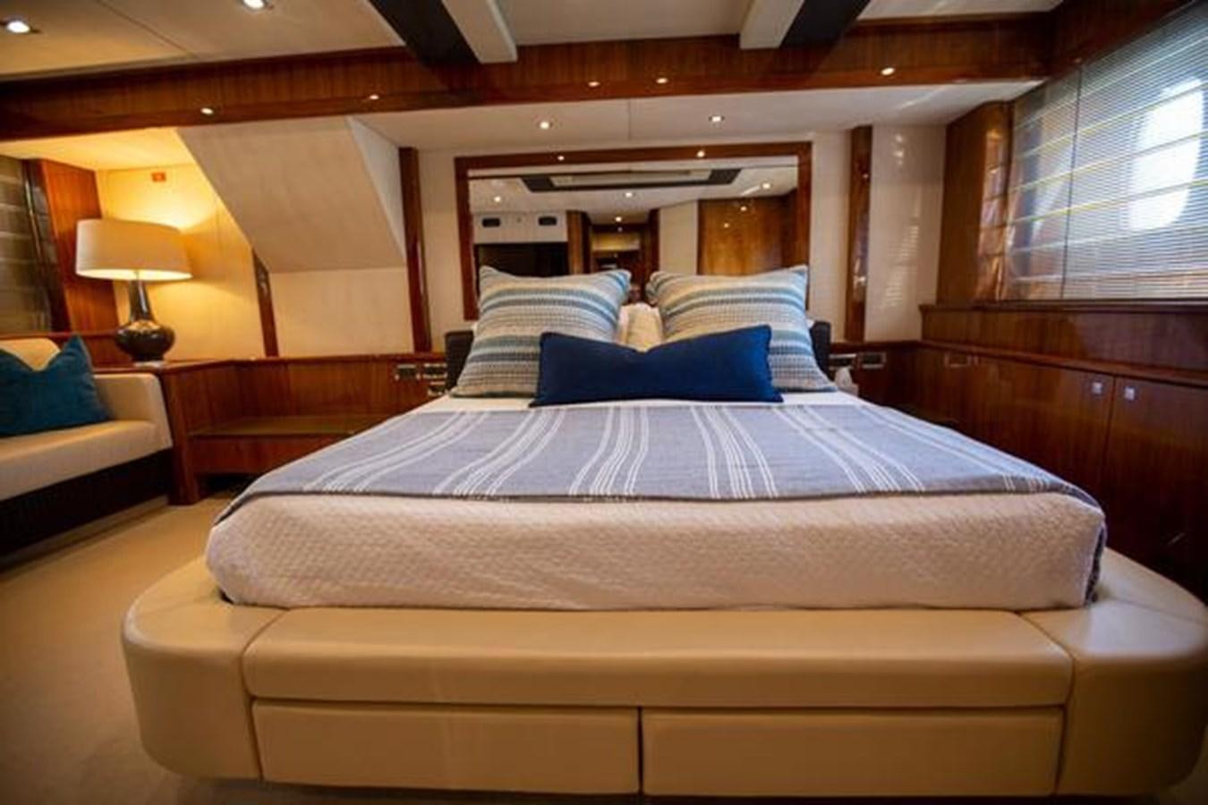 a bed with blue and white sheets aboard THE CABANA Yacht for Sale