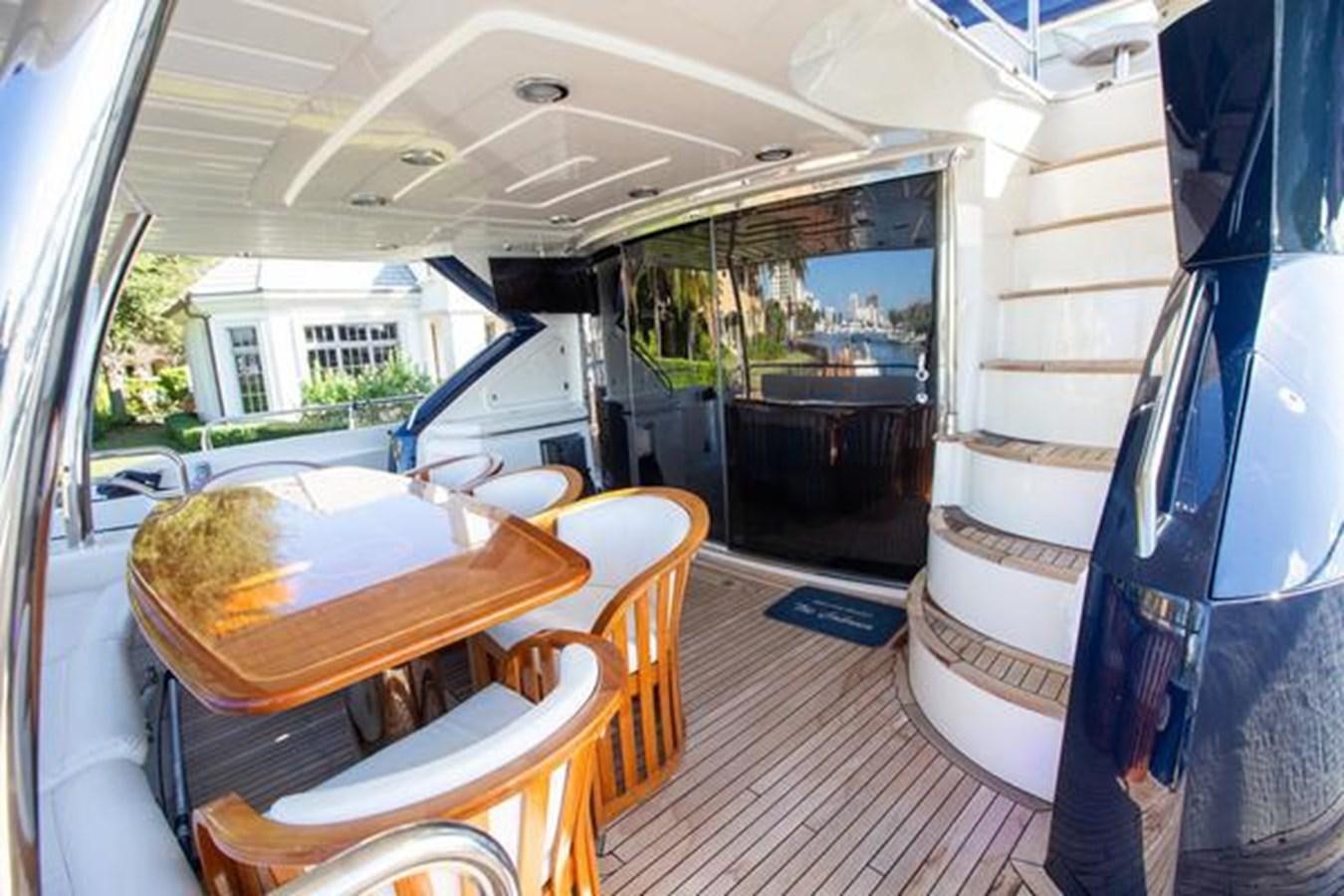a boat with a table and chairs aboard THE CABANA Yacht for Sale