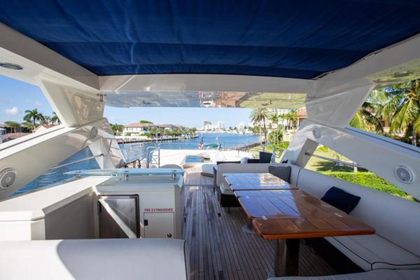a deck with a table and chairs aboard THE CABANA Yacht for Sale