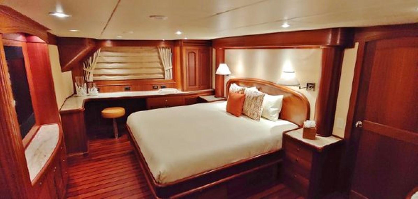 a room with a bed and desk aboard ALLSEAS 92 EXPEDITION Yacht for Sale