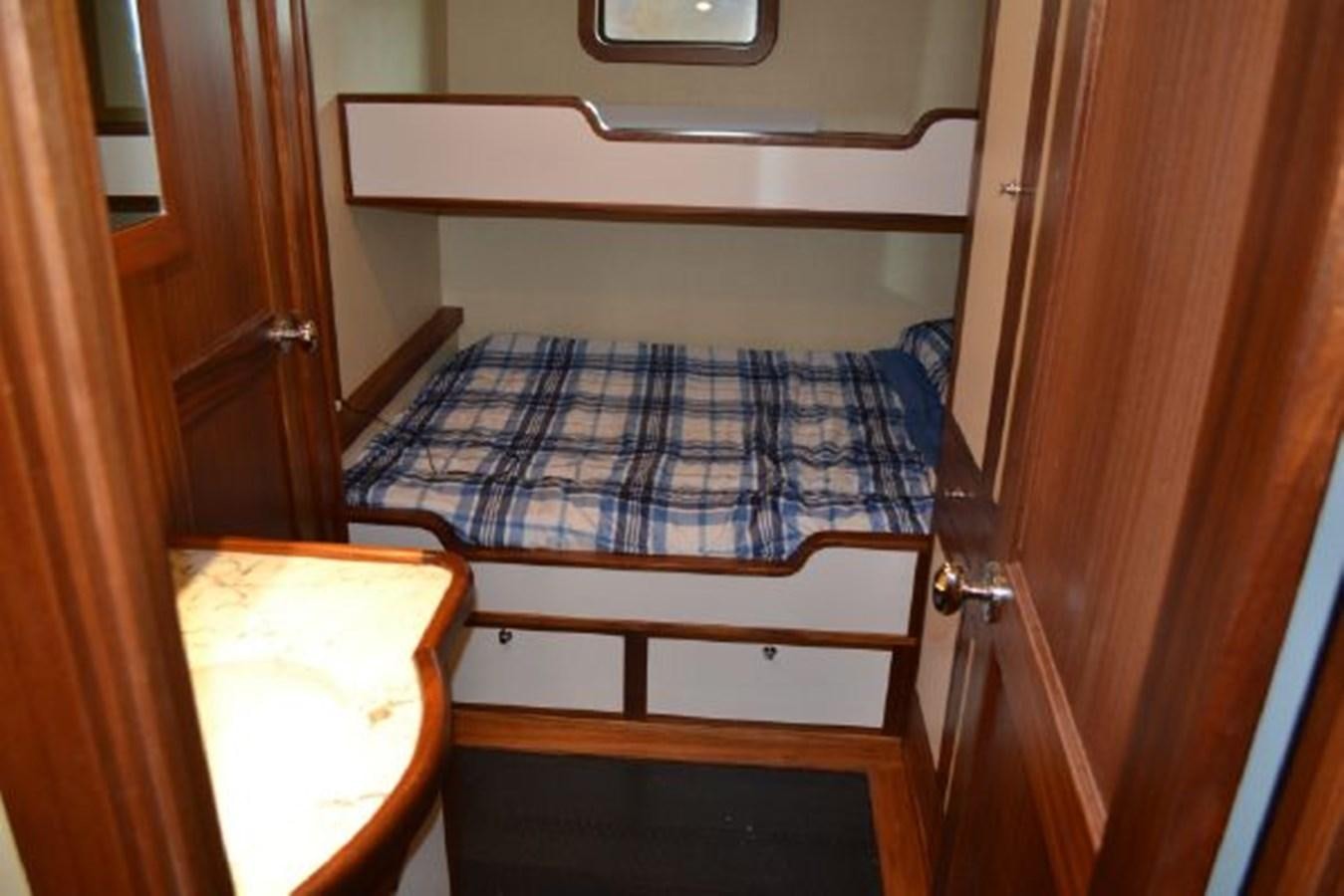 a bed with a blue comforter aboard ALLSEAS 92 EXPEDITION Yacht for Sale