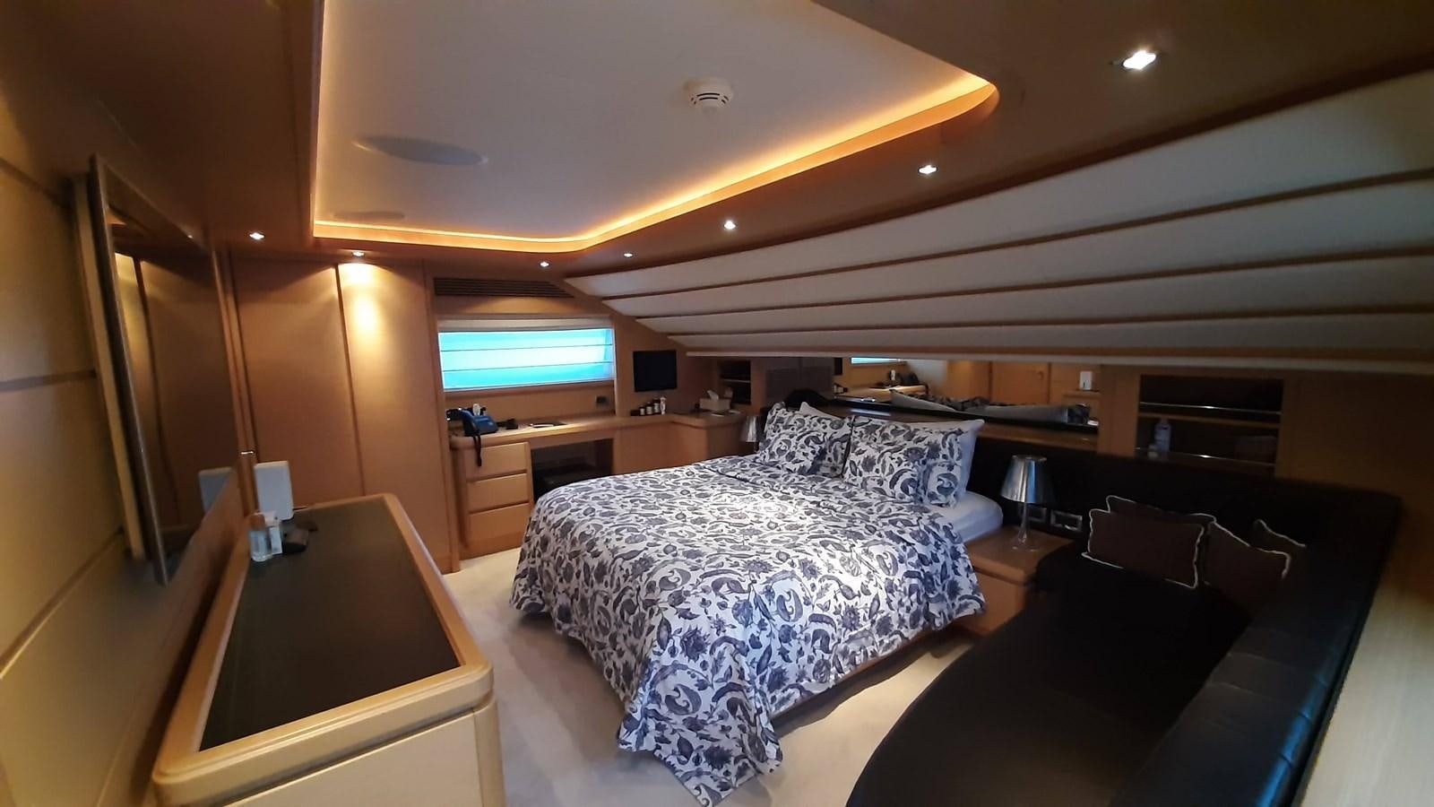 a bedroom with a bed and a desk aboard OKAMI Yacht for Sale