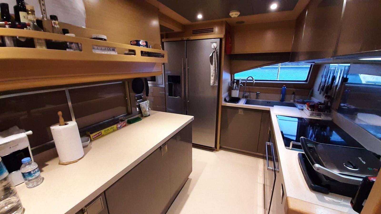a kitchen with a large refrigerator aboard OKAMI Yacht for Sale