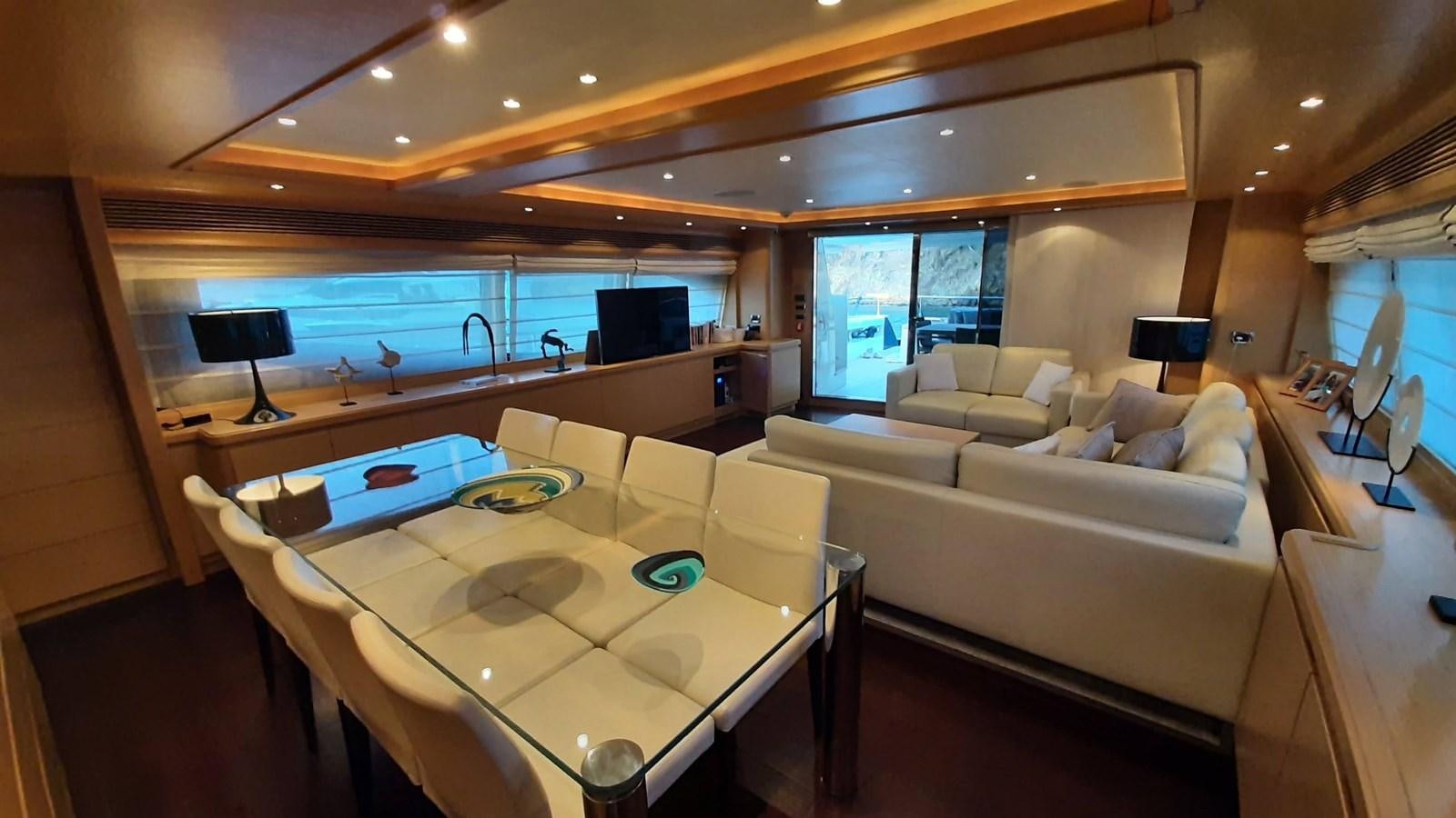 a room with a couch and a table with a laptop on it aboard OKAMI Yacht for Sale