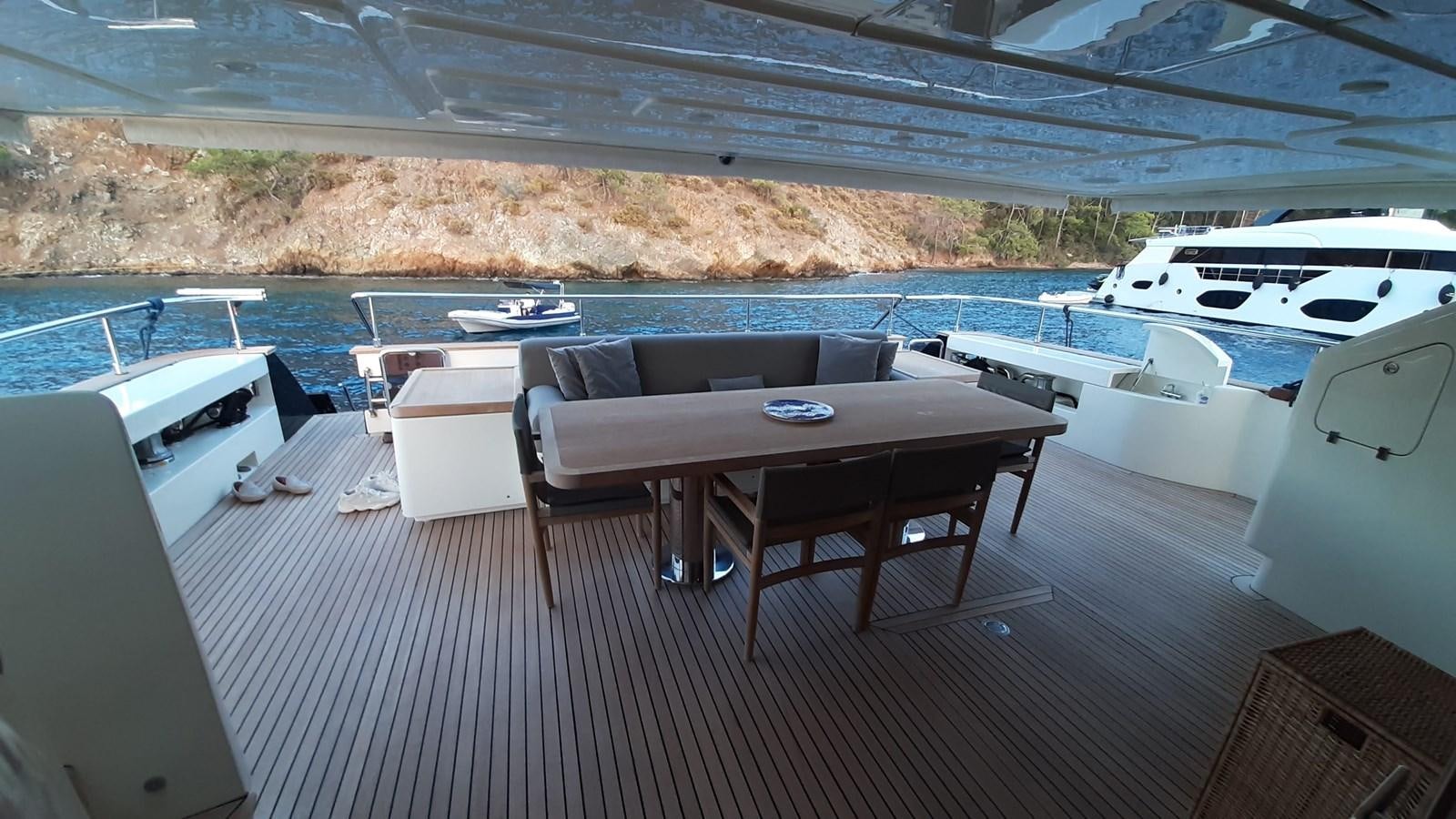 a table and chairs on a deck aboard OKAMI Yacht for Sale