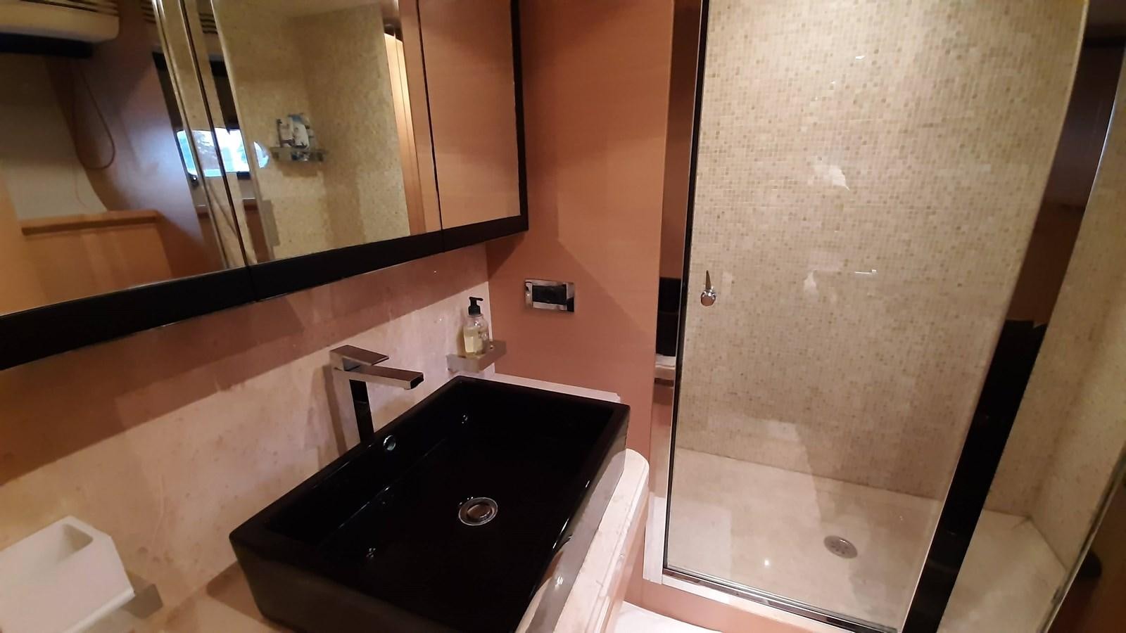 a bathroom with a tub sink and mirror aboard OKAMI Yacht for Sale