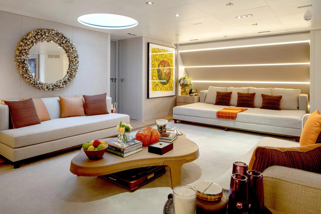 a living room with a white couch and a round mirror aboard MRS L Yacht for Sale