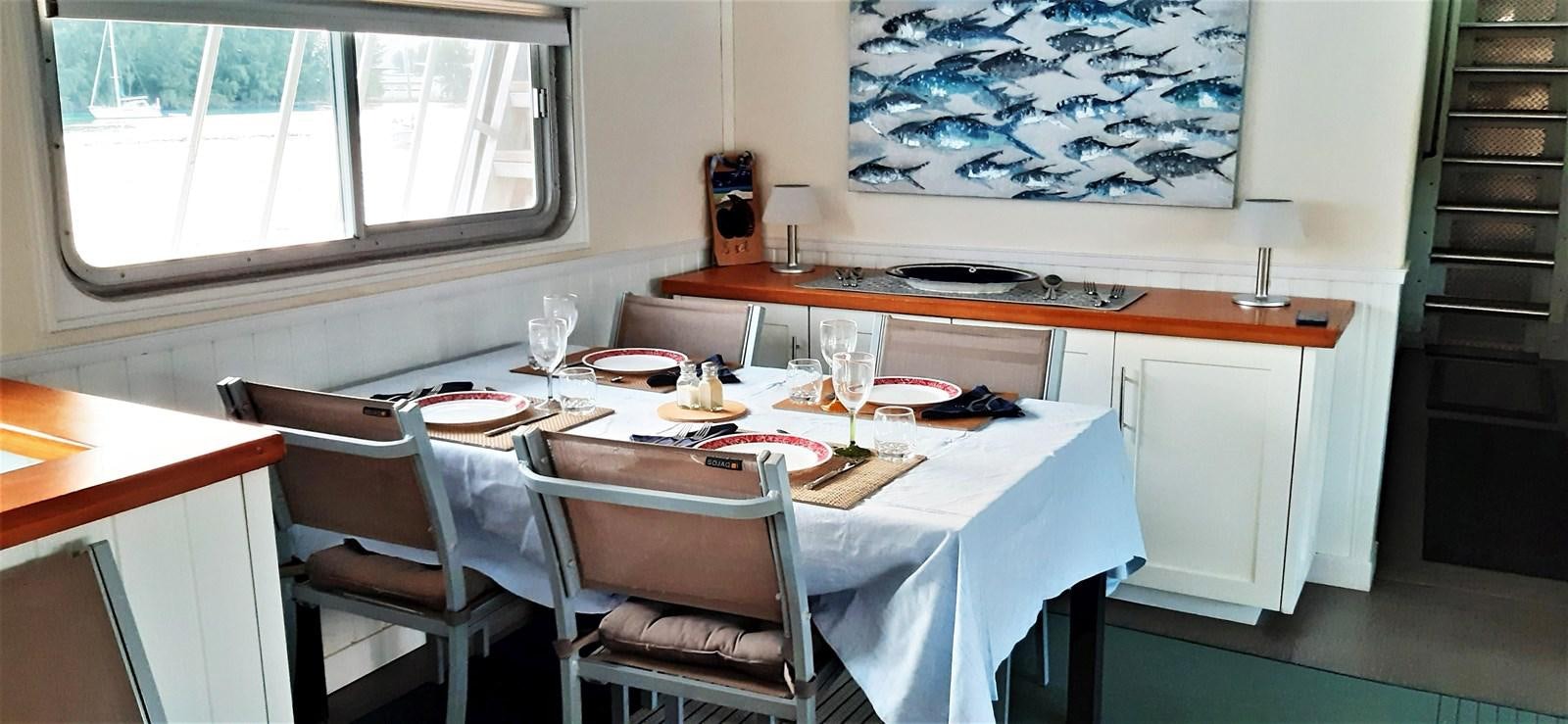 a table with chairs and a plate aboard BASILISK Yacht for Sale