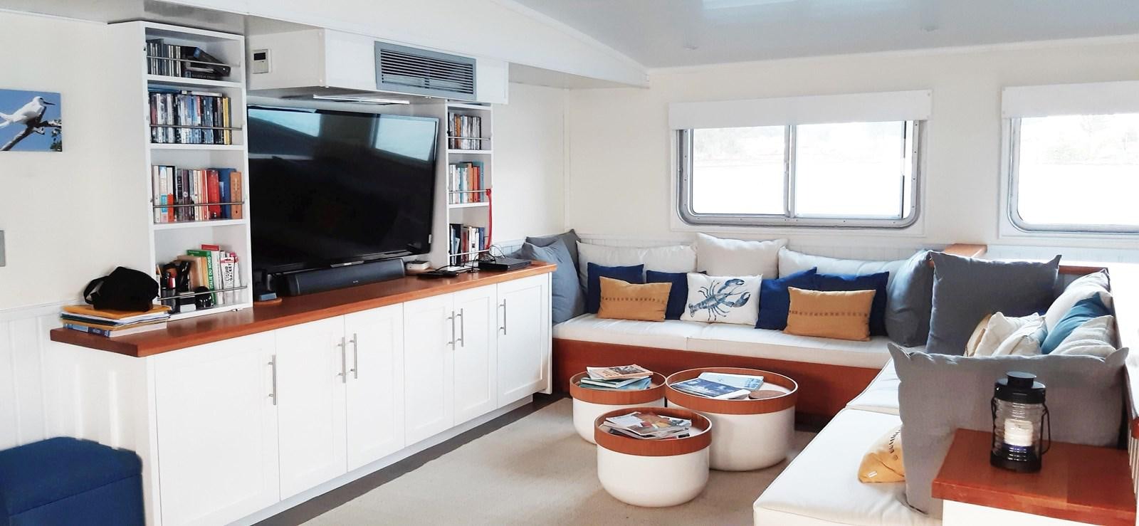 a living room with a couch and a television aboard BASILISK Yacht for Sale