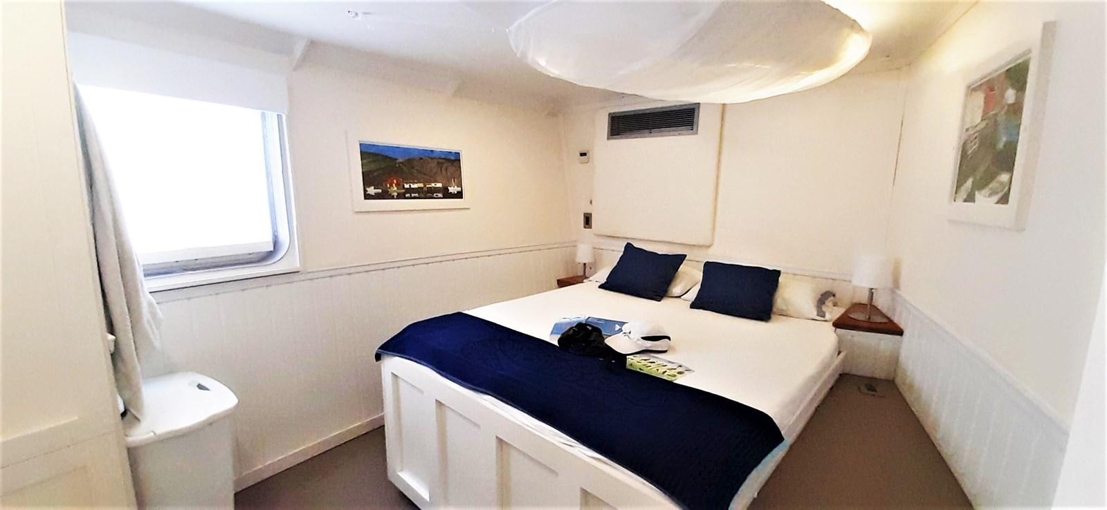 a bedroom with a bed and a desk aboard BASILISK Yacht for Sale