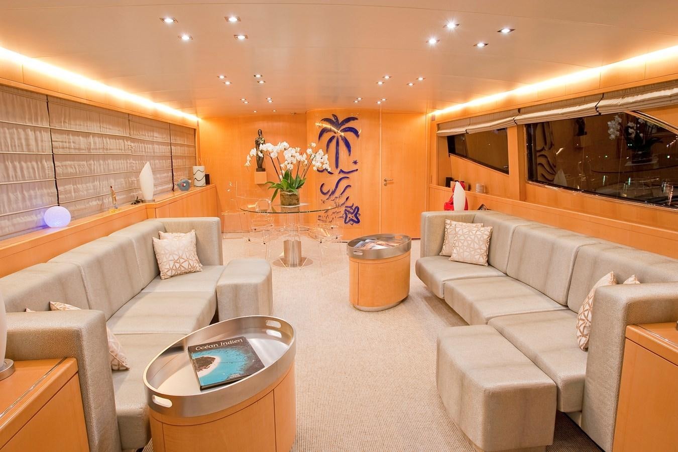a room with couches and a table aboard COCA VI Yacht for Sale