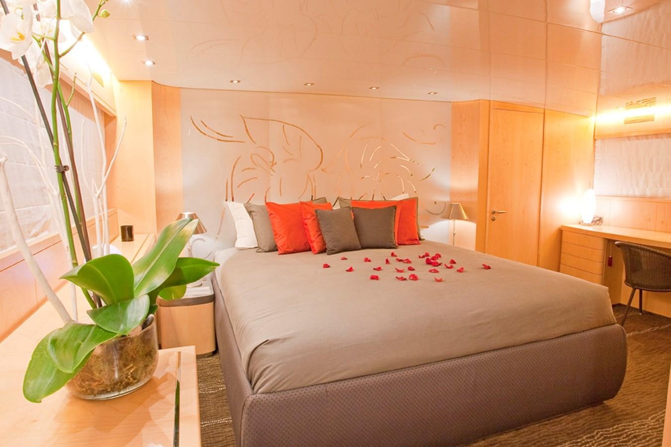 a bed with a plant on the side aboard COCA VI Yacht for Sale