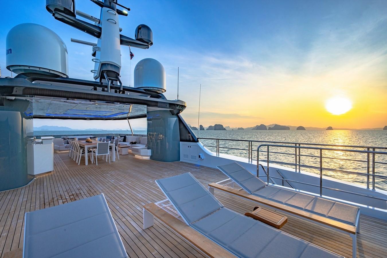 a deck of a boat on a body of water with a sunset aboard SONG OF SONGS Yacht for Sale