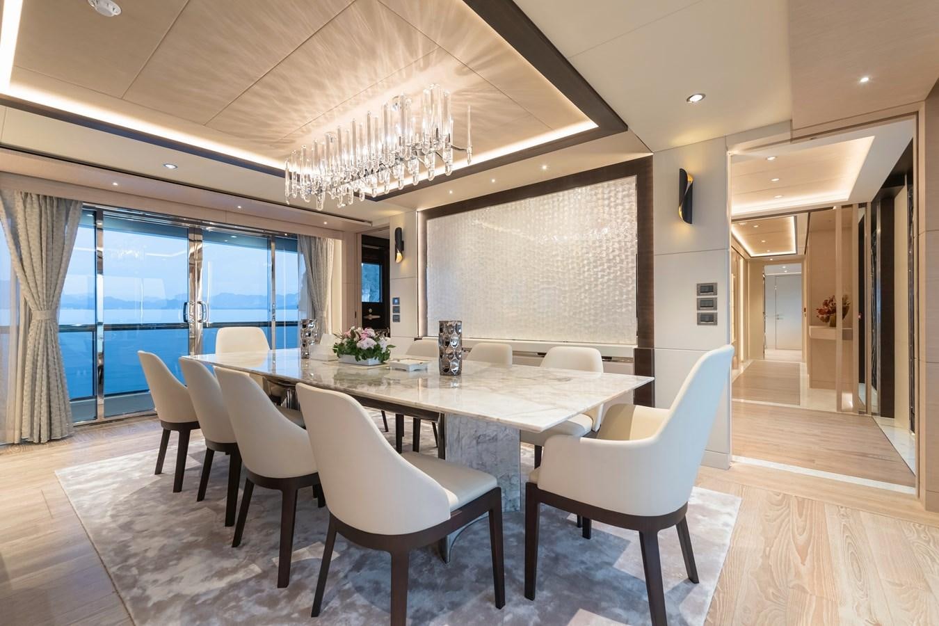 a large dining table with white chairs aboard SONG OF SONGS Yacht for Sale