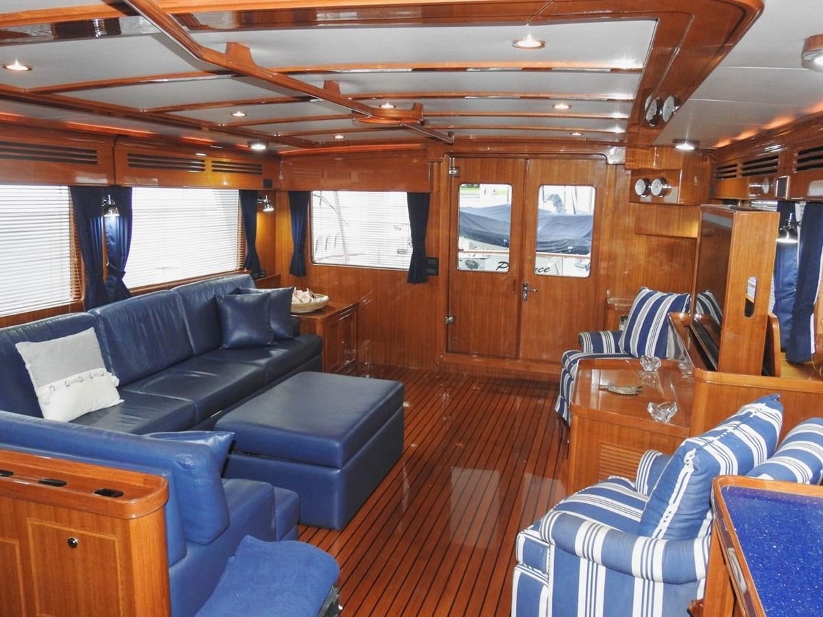 a living room with blue chairs and a wood floor aboard TELEMETRY Yacht for Sale