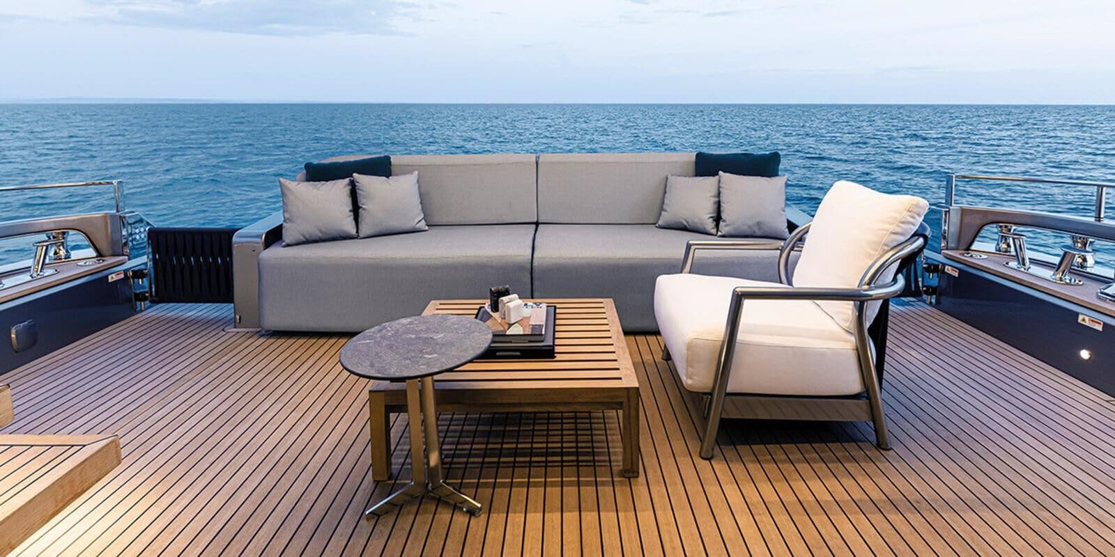 a couch and a table on a deck overlooking the ocean aboard SESSANTASETTE 67 Yacht for Sale