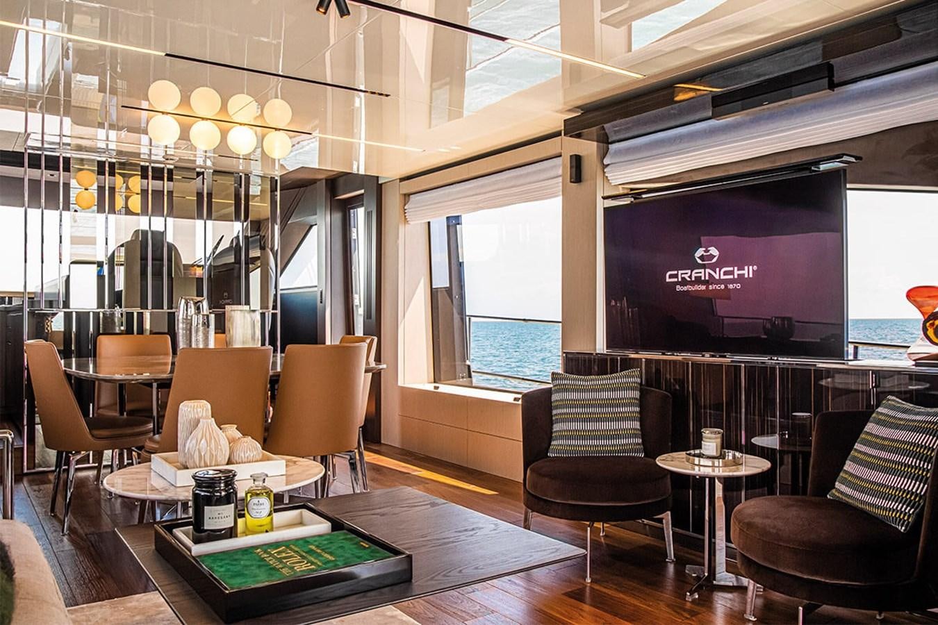 a room with a table chairs and a tv aboard SESSANTASETTE 67 Yacht for Sale