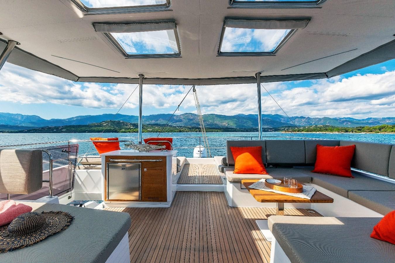 a room with a couch and a table and a view of the water aboard INSPIRANTE Yacht for Sale