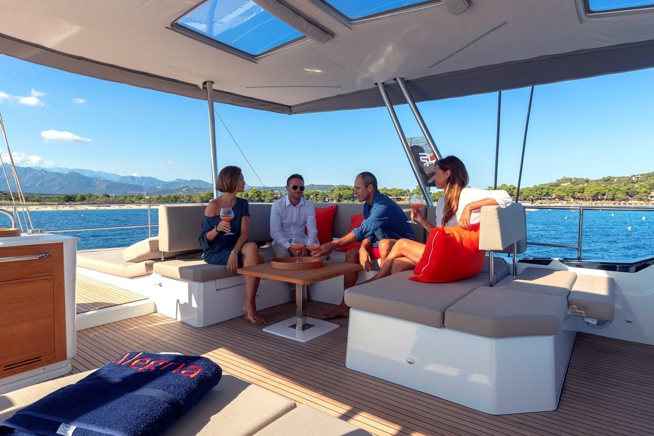 a group of people sitting on a boat on a deck aboard INSPIRANTE Yacht for Sale