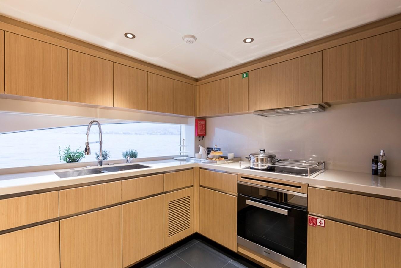 a kitchen with wooden cabinets aboard KRISHH Yacht for Sale