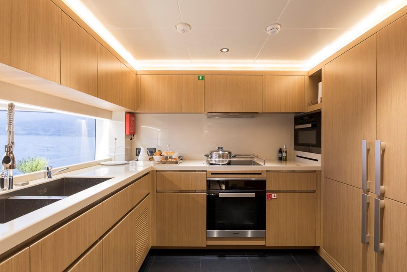 a kitchen with wooden cabinets aboard KRISHH Yacht for Sale