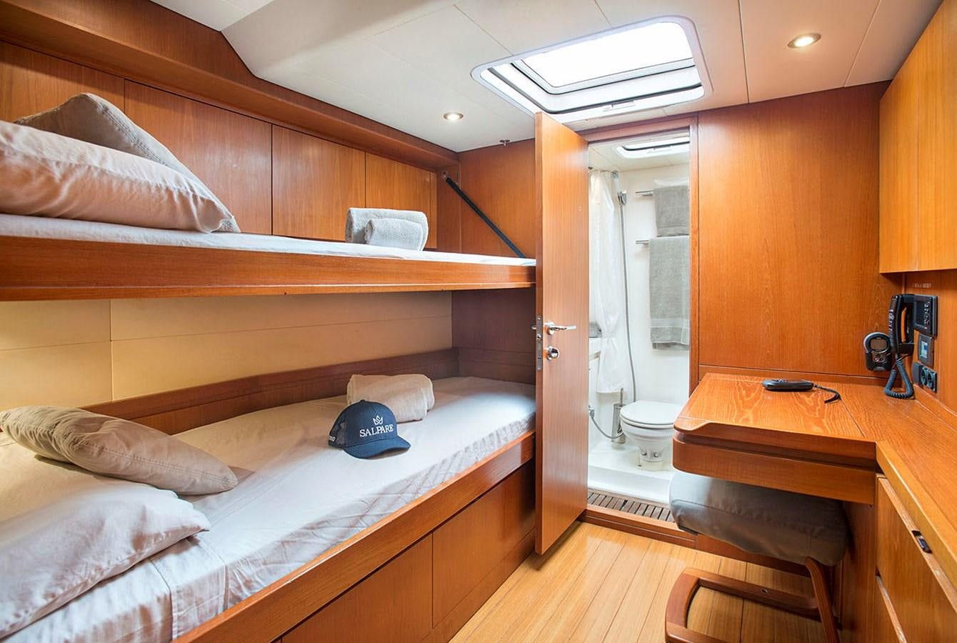 a bedroom with a bed and desk aboard SALPARE Yacht for Sale