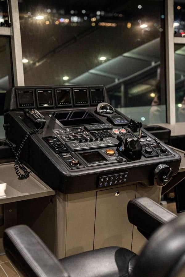 a black console with buttons and a controller on a table aboard COCHISE Yacht for Sale