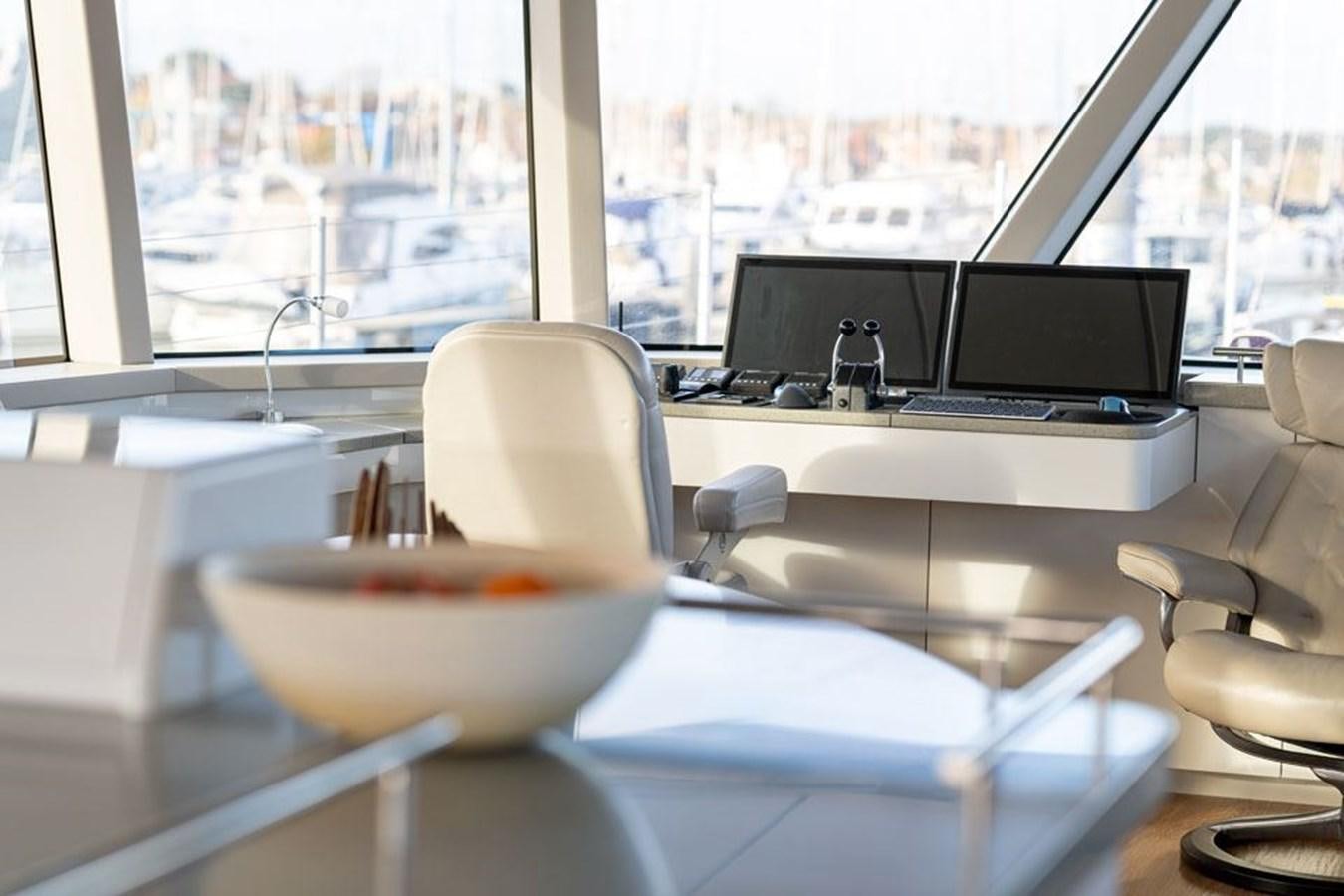 a white bowl on a table in a room with a window and a view of a city aboard COCHISE Yacht for Sale