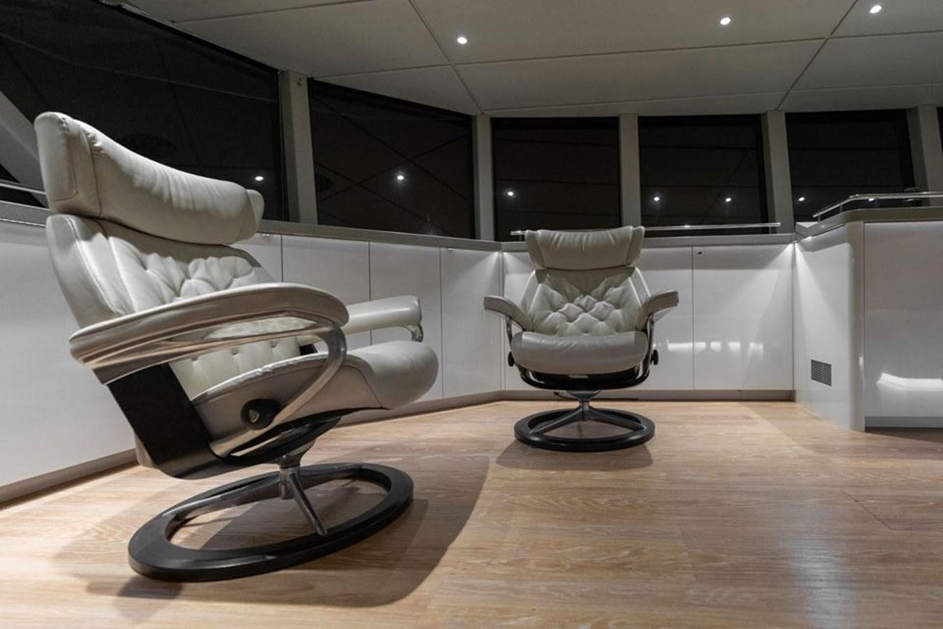 a couple of chairs on a wood floor in a room aboard COCHISE Yacht for Sale