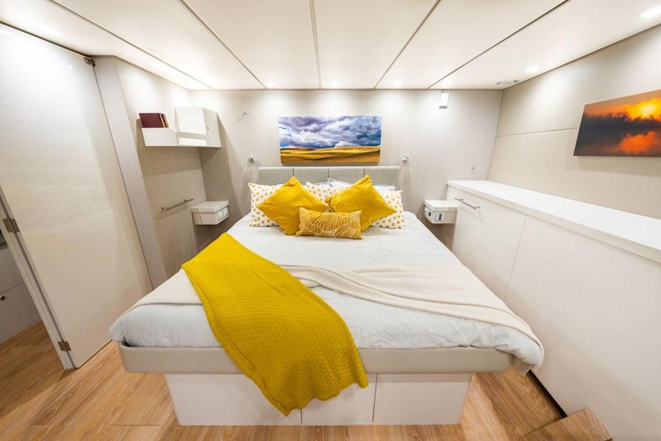 a bed with yellow pillows aboard COCHISE Yacht for Sale