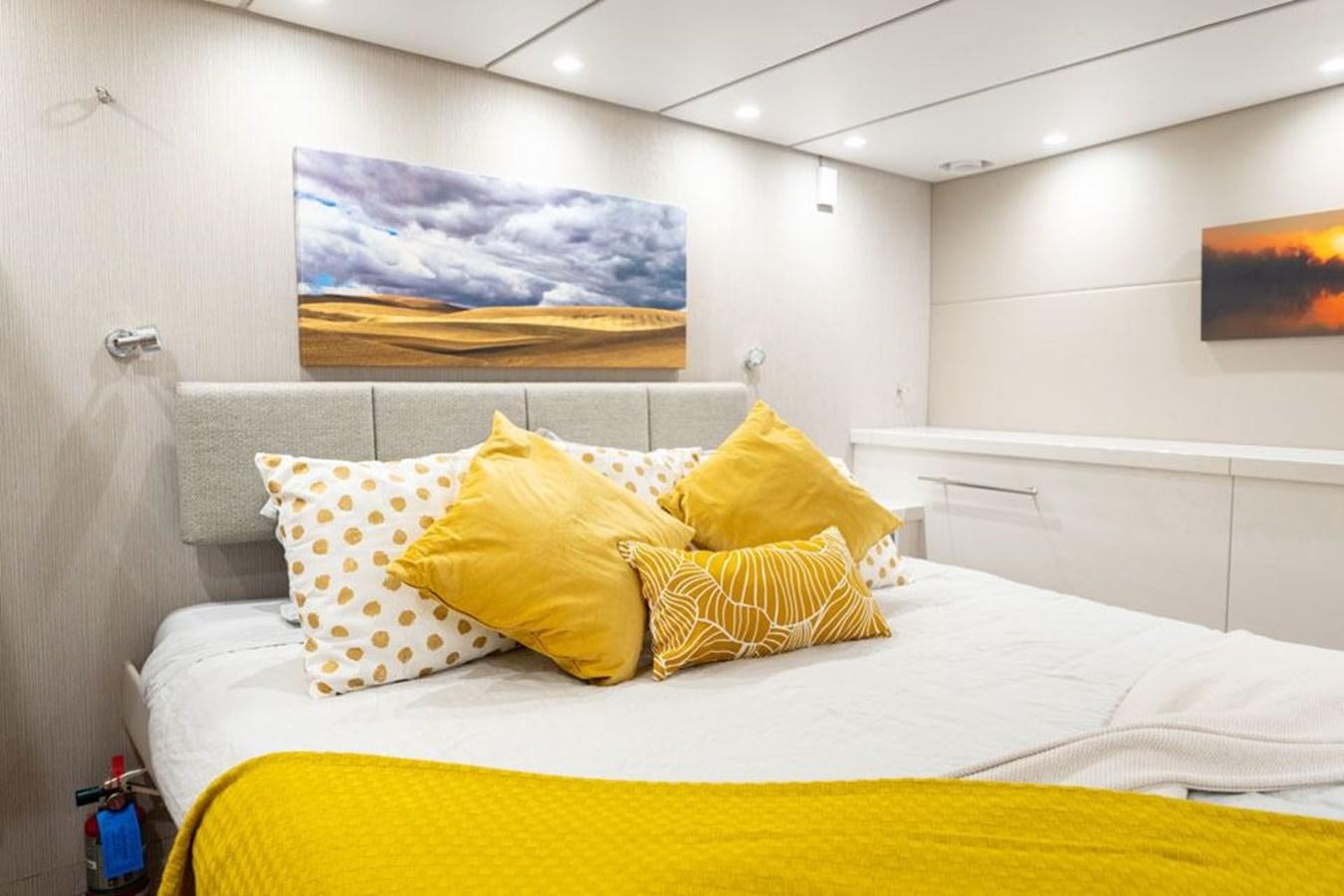 a bed with yellow pillows aboard COCHISE Yacht for Sale