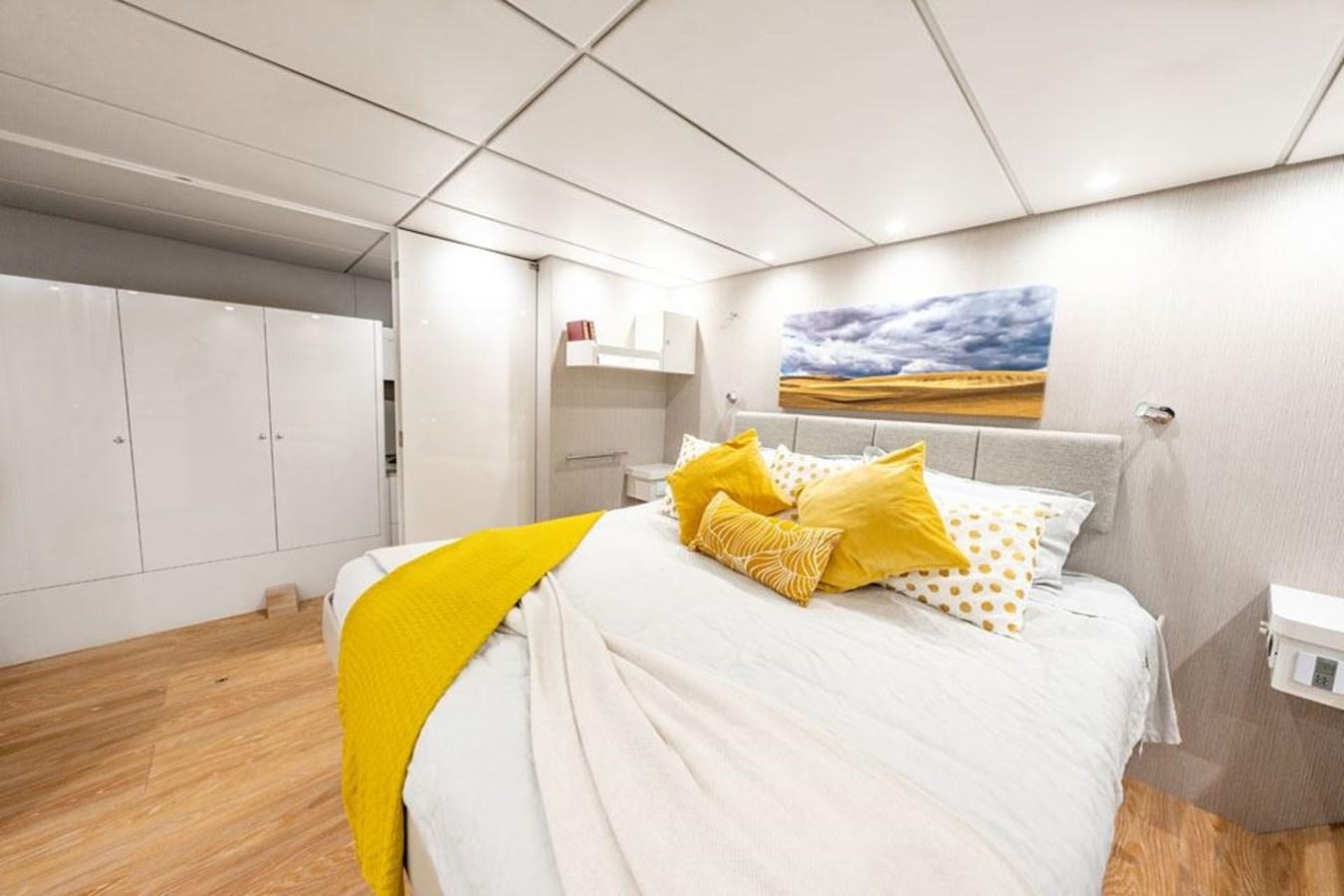 a bedroom with a bed and a desk aboard COCHISE Yacht for Sale