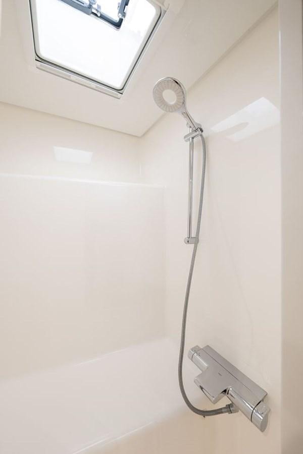 a shower head in a white bathroom aboard COCHISE Yacht for Sale